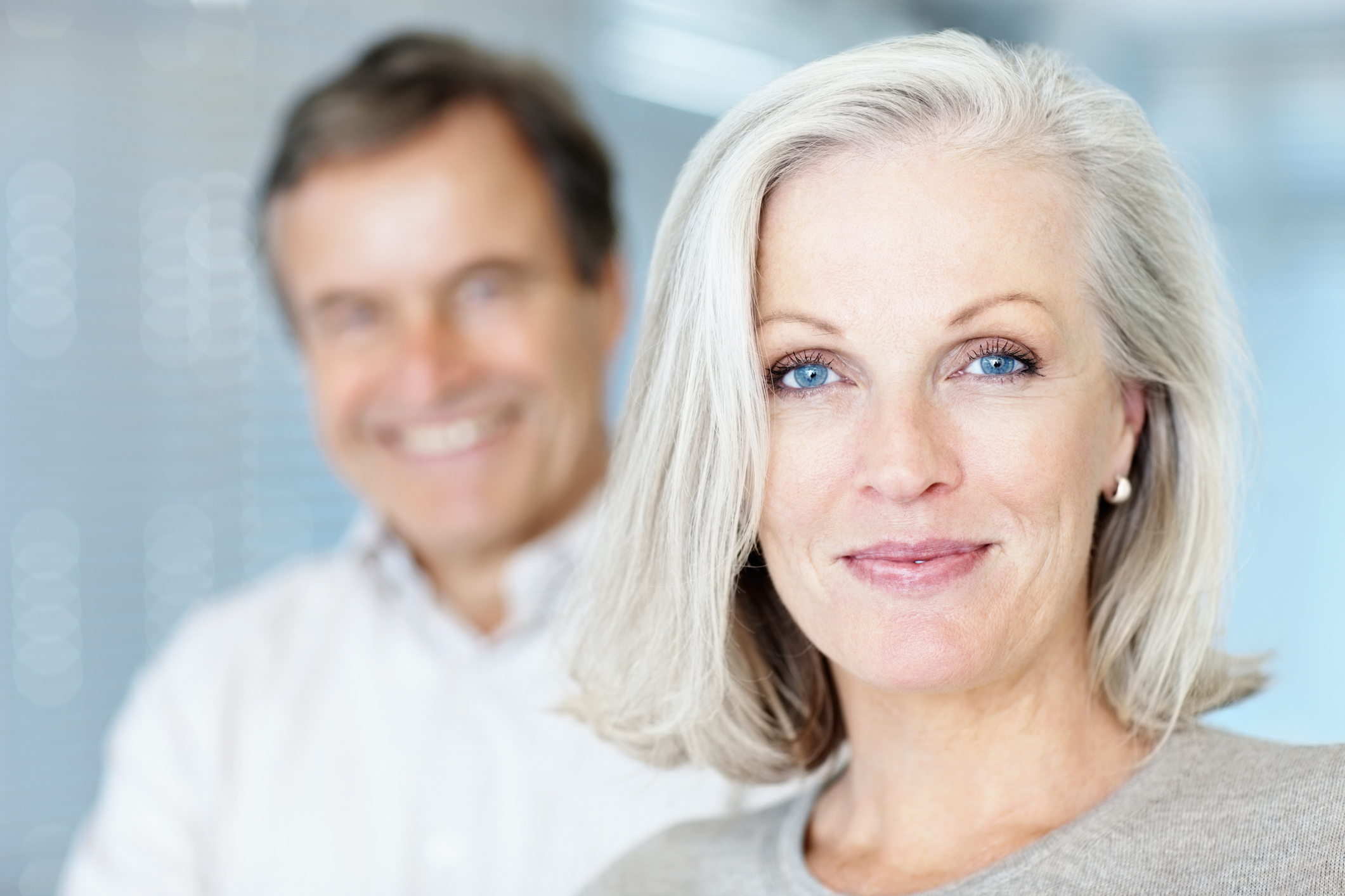 Mature woman smiling with man in the background