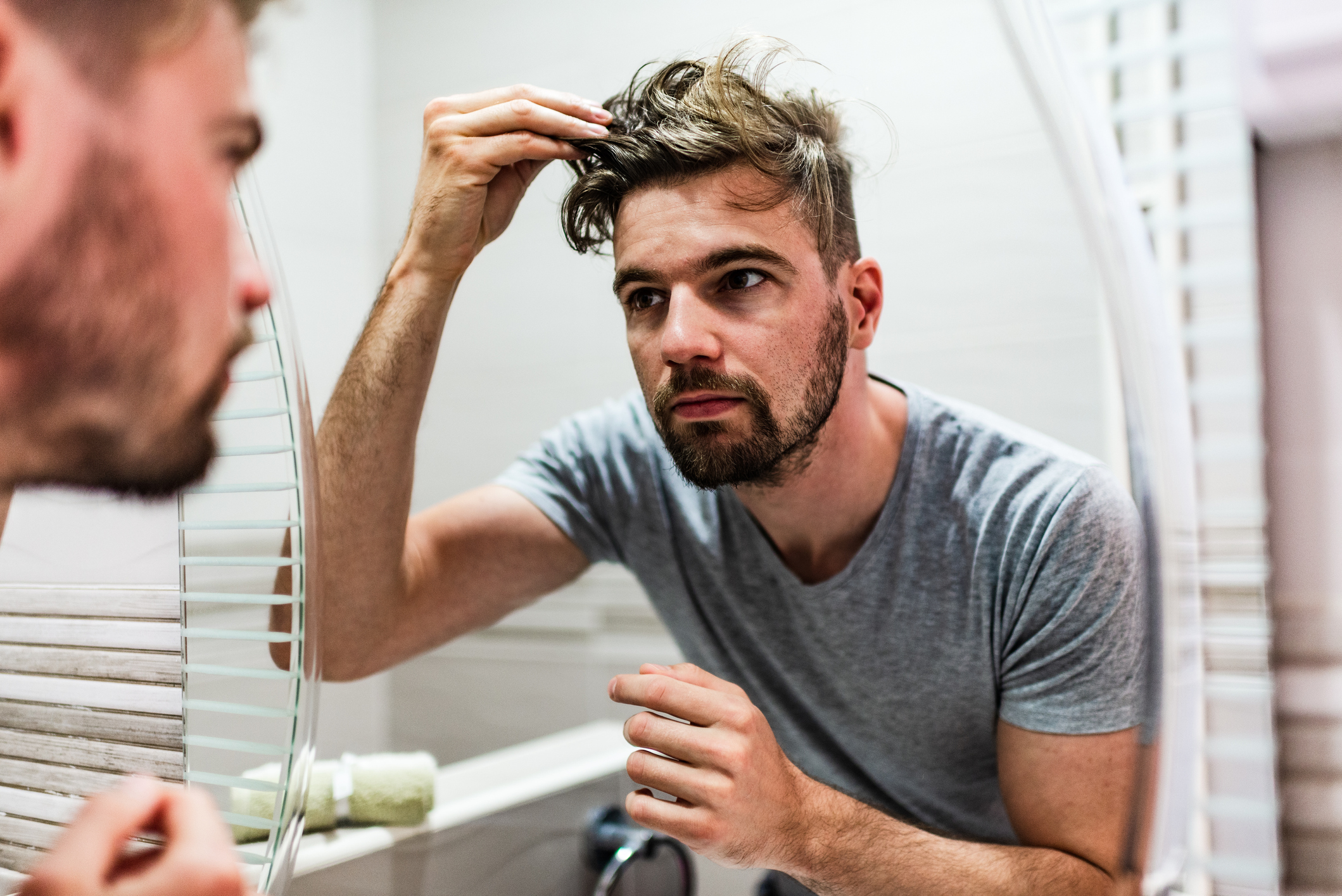 Man styling his hair after effective results of PRP hair restoration